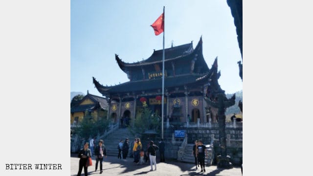 Imponente bandera nacional colocada frente a un templo budista