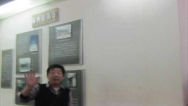 Un guardia de seguridad intenta evitar que se tome una fotografía de la exposición de la historia judía de Kaifeng