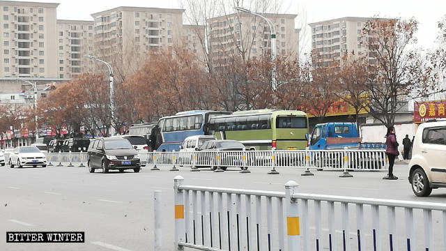 Coches de la policía especial y dos enormes autobuses estacionados afuera del hotel Haoyue