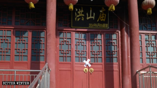 La puerta del Templo de Hongshan ha sido sellada con cinta de barricada.