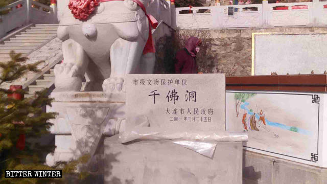 Tablilla de piedra que indica que la Cueva de los Mil Budas