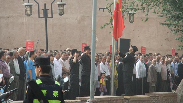 Uigures se reúnen en Kasgar para la reunión política obligatoria del lunes por la mañana. La no asistencia trae aparejadas severas sanciones y, a menudo, detenciones para ser sometido a reeducación, o incluso algo peor.