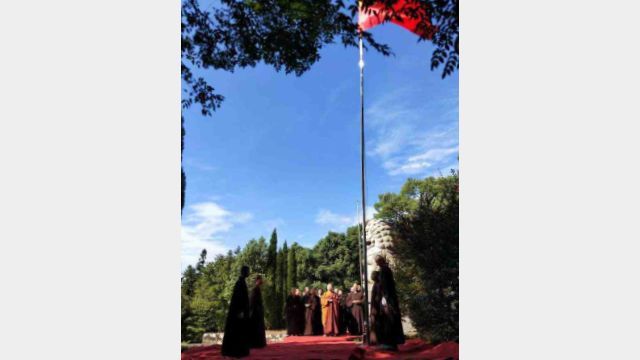 Monjes budistas asisten a una ceremonia de izamiento de la bandera