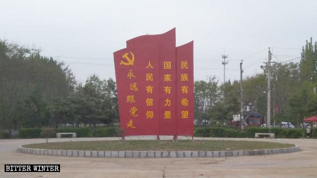 Un letrero propagandístico fue colocado en el sitio original de la escultura del Corán.