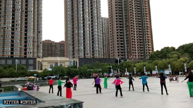 Grupo de personas haciendo ejercicios aeróbicos al son de canciones budistas en la provincia de Henán.