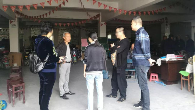 Miembros de un "equipo compuesto por tres personas" hablando con el personal a cargo de un lugar religioso.