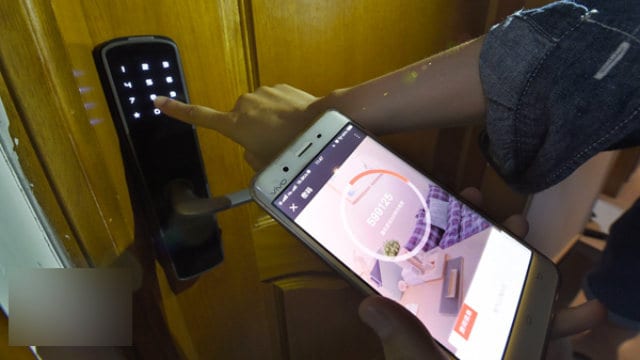 Un trabajador está probando la cerradura inteligente con una aplicación móvil.