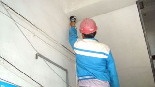 Un trabajador está instalando una cámara de vigilancia.