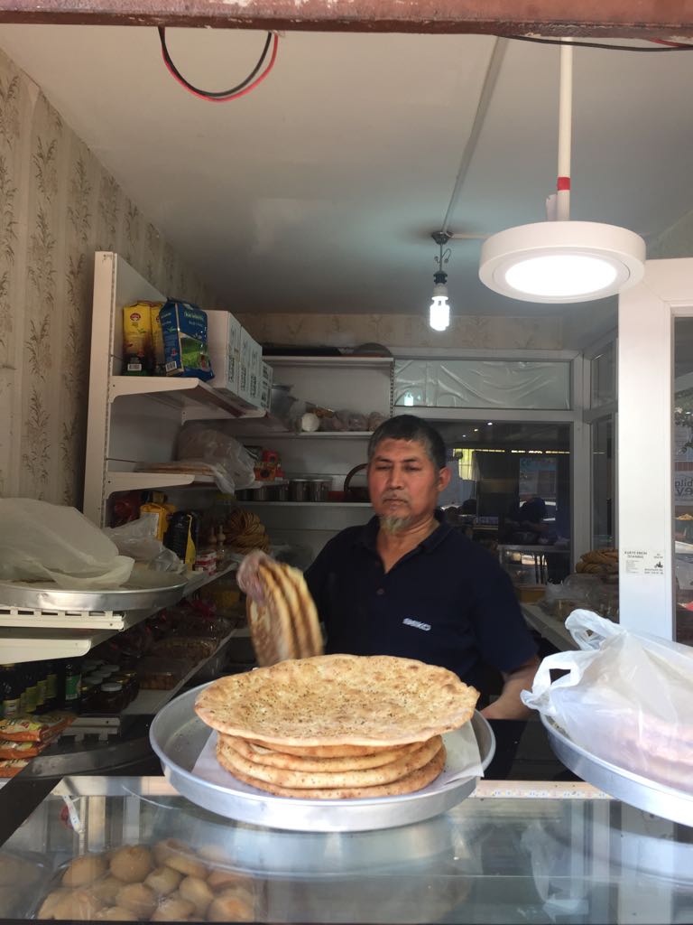 Este panadero de Kashgar muestra orgullosamente su pan “naan” bien caliente acabado de salir del horno tandoor.