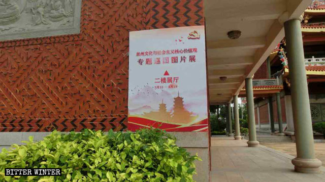 Cartel propagandístico de la “Exposición fotográfica y recorrido temático de cultura y valores socialistas fundamentales de Quanzhou” exhibido en la pared del templo de Jieguanting.
