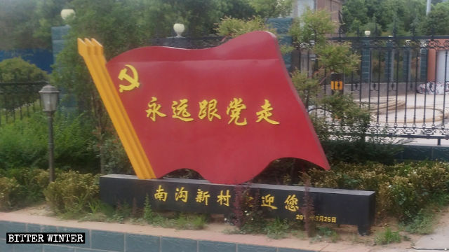 Una exhibición de propaganda en la forma de la bandera nacional en un área residencial dice: “Siempre sigue al Partido”.
