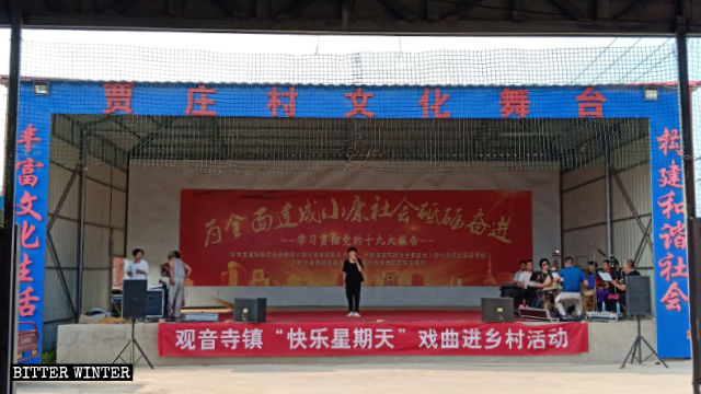 Presentación en el Teatro Cultural de la villa de Jiazhuang. Un letrero que dice “domingo feliz” cuelga en el escenario.
