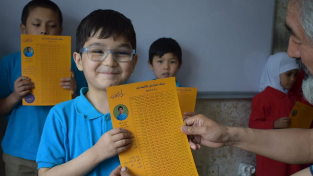 Los alumnos de la escuela de Hira’i reciben sus calendarios del Ramadán.