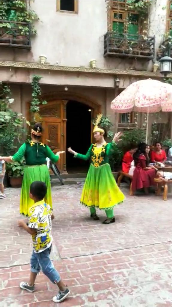 Con un rostro bastante infeliz, las adolescentes uigures son obligadas a bailar para los turistas de etnia han en Kashgar.