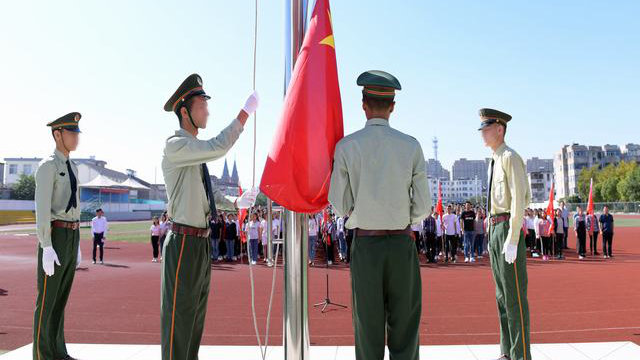 Estudiantes de Sinkiang en la preparatoria de Kou’an en Jiangsu participan en una ceremonia de izamiento de la bandera.