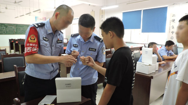 Funcionarios de la agencia de seguridad pública de la ciudad de Shifang, en Sichuan, recogen muestras de ADN de estudiantes de secundaria.