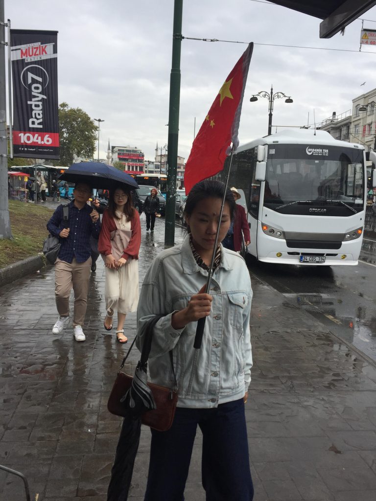 La bandera roja china ondea en lo alto de las calles de Estambul mientras una guía de turismo conduce a sus visitantes a través de antiguos bazares.