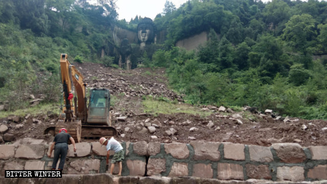 Trabajadores de la construcción están construyendo un muro de contención mientras se preparan para cubrir la estatua de Buda.