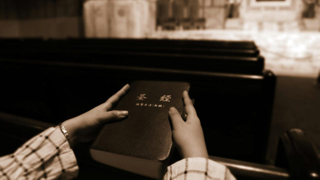 Un creyente sostiene la Biblia, la cual siempre es confiscada por la policía cuando se allanan iglesias domésticas.