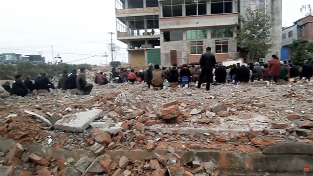 Cristianos de un condado en Fuyang se reúnen en un campo de ruinas.