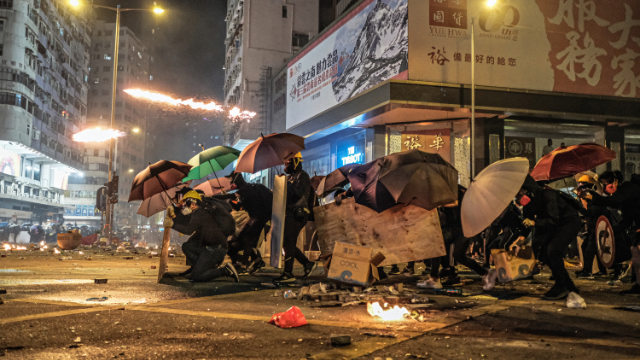 Manifestantes de Hong Kong se defienden de los ataques con gases lacrimógenos efectuados por la policía.