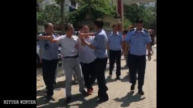 Oficiales de policía están deteniendo a un fiel de la Iglesia de Zhongxin.