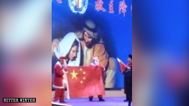 Un actor que interpreta a Papá Noel sostiene una bandera china durante la representación.