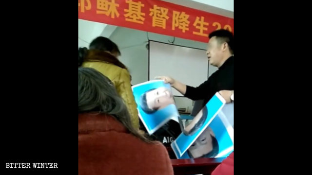 Un funcionario gubernamental distribuye retratos de Xi Jinping entre los creyentes.