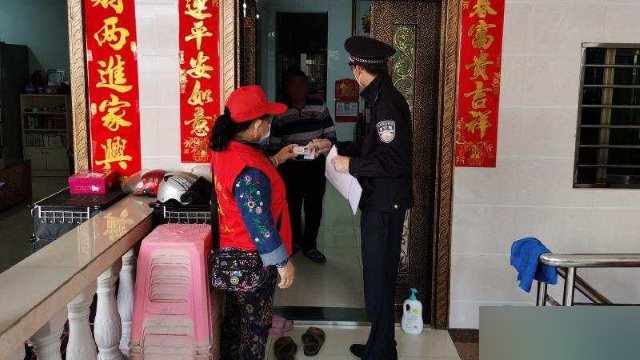 En la ciudad de Sanya de la provincia de Hainan, un miembro del personal comunitario, acompañado por un oficial de policía, va de puerta en puerta para verificar la información de identificación de los residentes.