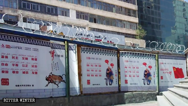 En un muro con alambre de púas se han colocado carteles propagandísticos que promueven el sueño chino del presidente Xi Jinping.