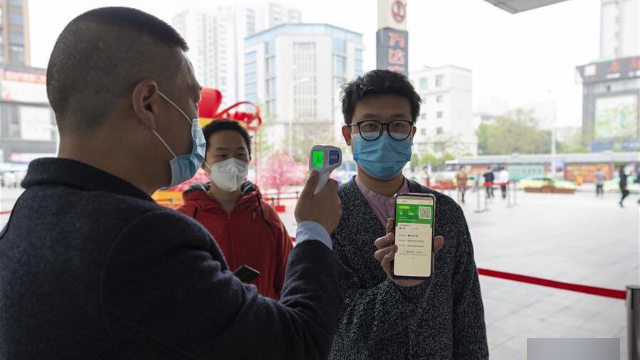 Personas muestran sus códigos de salud antes de ingresar a un centro comercial emplazado en Xiangyang, una ciudad a nivel de prefectura de la provincia central de Hubei.