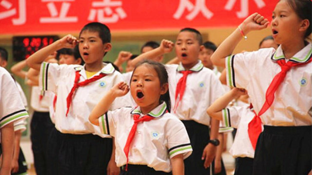 En una escuela primaria emplazada en la región autónoma hui de Ningxia, miembros del Cuerpo de Jóvenes Pioneros del PCCh prestan juramento durante una actividad desarrollada bajo la temática, "El corazón del pañuelo rojo sigue al Partido" llevada a cabo en el Día del Niño.