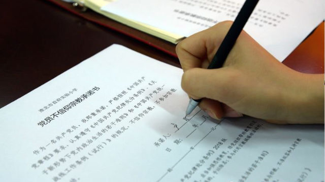 Los maestros de la Escuela Primaria Experimental de la capital de Huaibei emplazada en la provincia oriental de Anhui, firman declaraciones en las que prometen no tener creencias religiosas.
