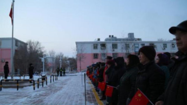 Una comunidad residencial de Sinkiang organiza a sus residentes para una ceremonia de izamiento de la bandera.