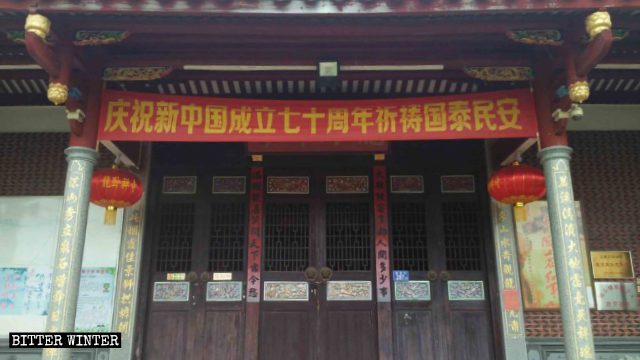 En la entrada del Templo de Longwo cuelga una pancarta, celebrando el 70.° aniversario de la fundación de la nueva China.