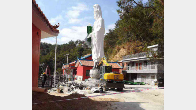 Los trabajadores están demoliendo la estatua de “Kwan Yin que derrama gotas de agua”.