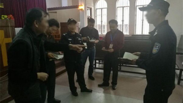 Varios funcionarios y oficiales de policía retiran publicaciones religiosas de una iglesia emplazada en la ciudad de Enping de Cantón.